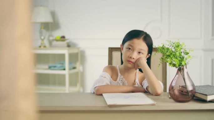 坐在办公桌前思考的亚洲小女孩