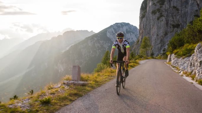 男性公路自行车手在山腰上坡骑自行车