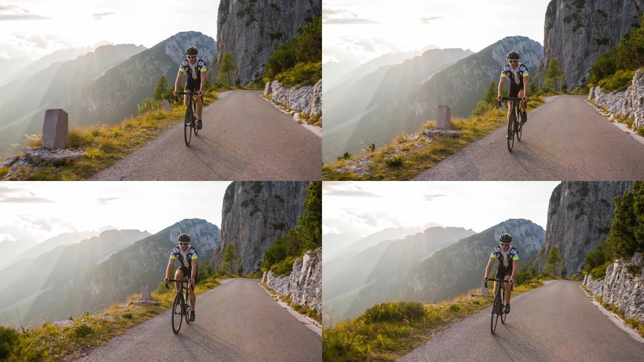 男性公路自行车手在山腰上坡骑自行车