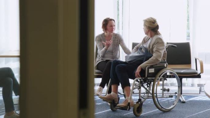 女人在医院与残疾母亲交谈