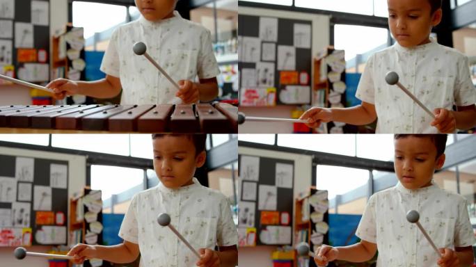 在学校的教室里玩木琴的亚洲男生的前视图4k