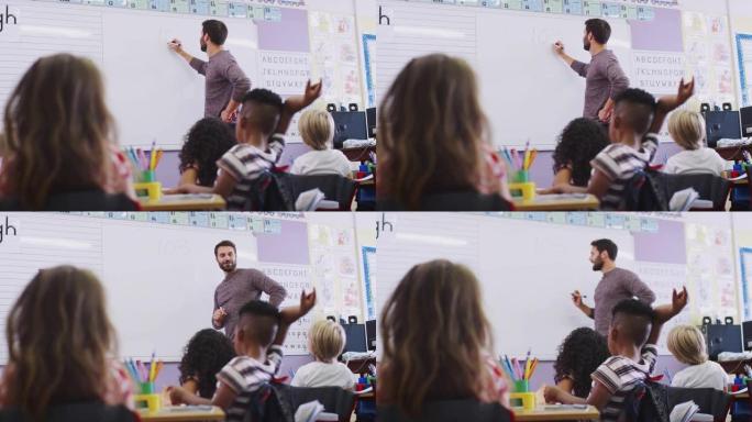 站在白板上的男老师在学校教室里给小学生上课