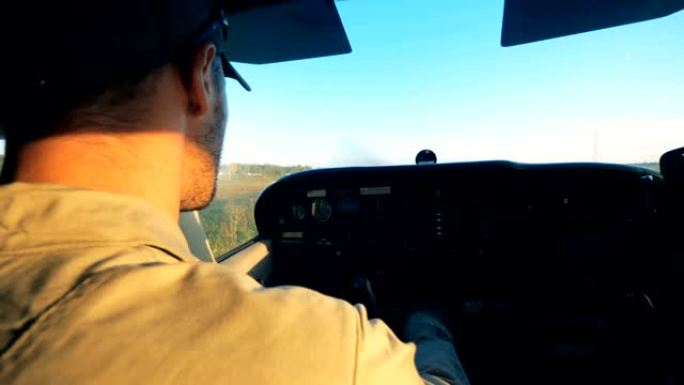 一名男性飞行员坐在驾驶舱中驾驶飞机的特写镜头
