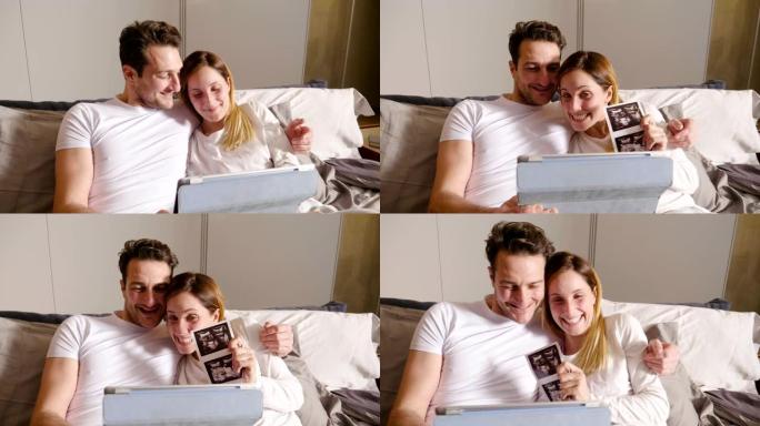 一对恋爱中的已婚夫妇使用平板电脑对父母进行视频拍摄，以宣布儿子的出生显示超声波。