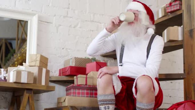 圣诞老人坐在木楼梯上在家喝茶