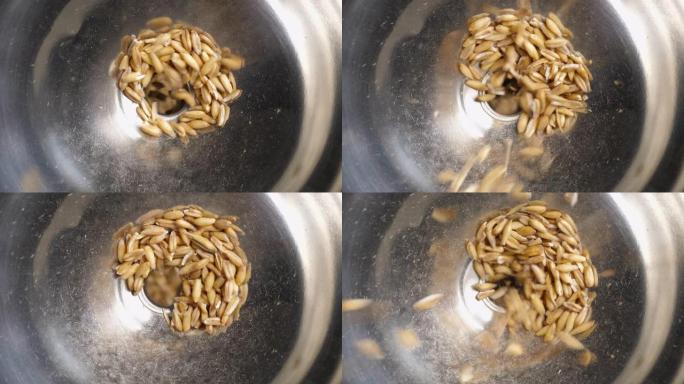 漏斗磨中的燕麦种子。特写镜头。