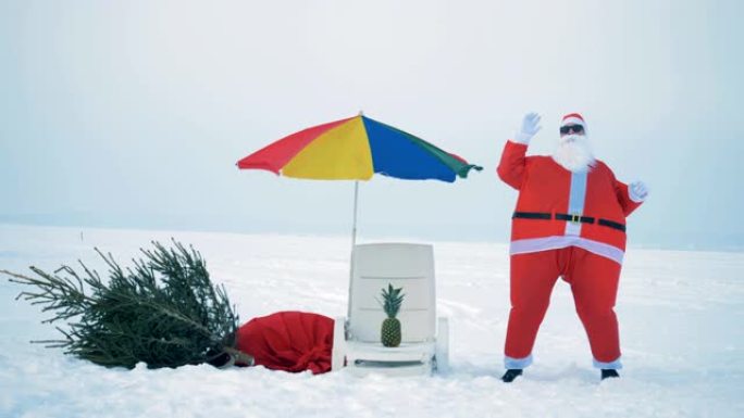 在白雪皑皑的海滩绿洲附近跳舞的圣诞老人