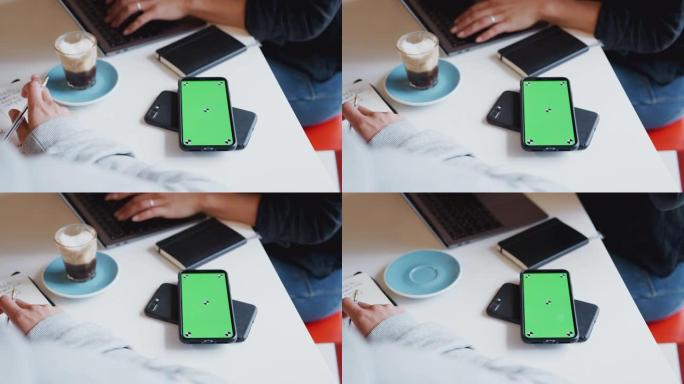 两个绿屏手机的特写镜头可以在桌子上无线充电