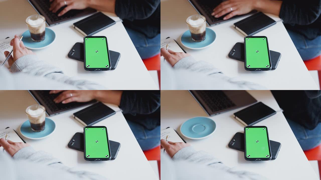 两个绿屏手机的特写镜头可以在桌子上无线充电