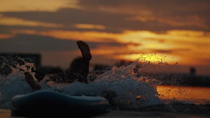 超级SLO MO笨拙的桨手在日落时掉入水中