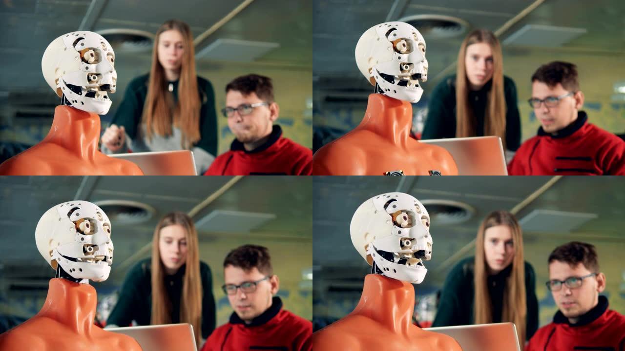 工程师看着机器人移动它的脸，特写。