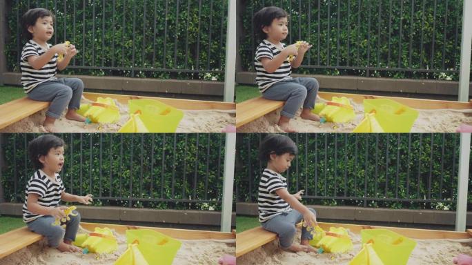 亚洲男婴在后院的沙箱外面玩耍