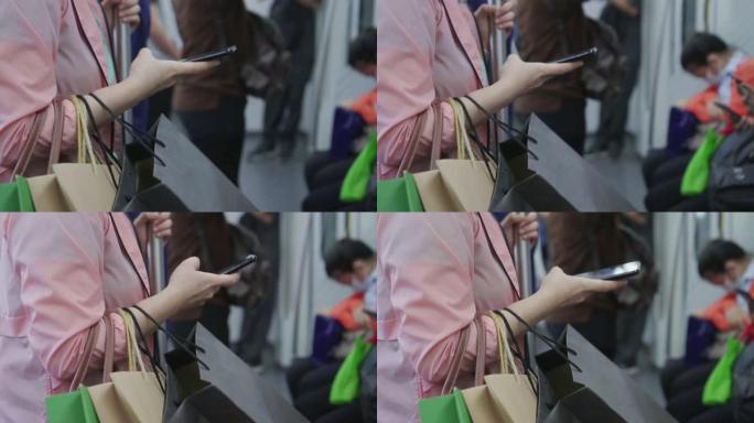 年轻女子在乘坐地铁时使用智能手机，慢动作