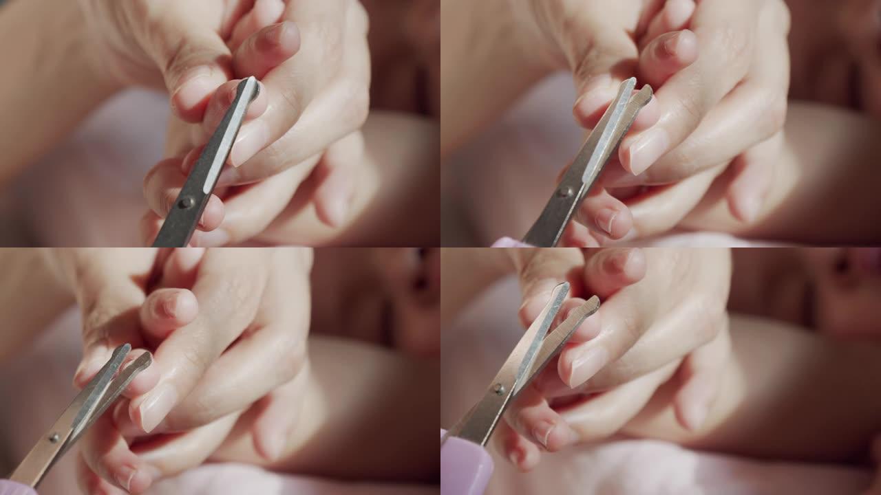 妈妈在家用指甲剪在婴儿身上剪指甲的特写镜头。婴儿身体护理概念。特写镜头前视图