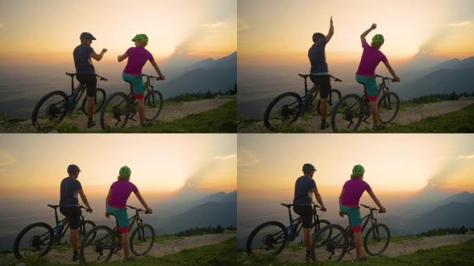 慢动作: 年轻的朋友在晚上庆祝成功的山地自行车骑行。