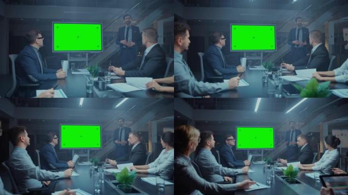 深夜在公司会议室: 董事交谈并使用数字色度键交互式白板向高管，投资者进行演示。水平模式下的绿色模拟屏