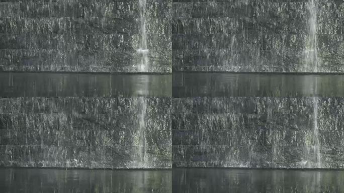 4k镜头现代水幕场景与岩石和砖墙、室内喷泉和装饰瀑布概念