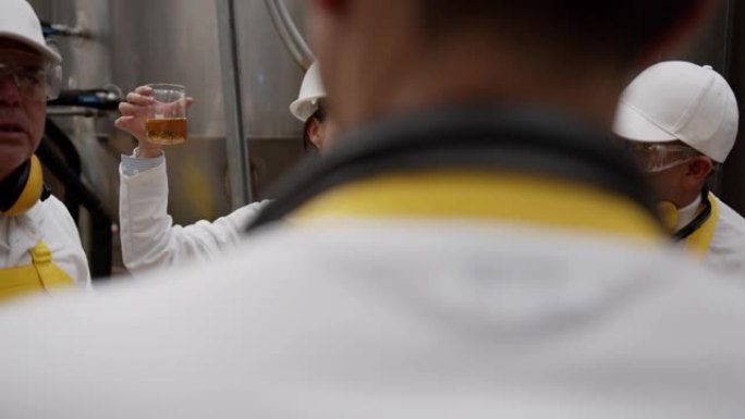 一群拉丁美洲经营者在一家啤酒厂的主管正在看啤酒样品