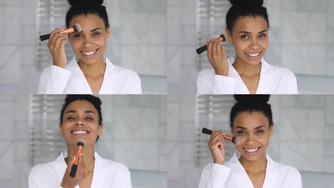 微笑迷人的非洲女人拿着刷子在脸上涂抹粉末