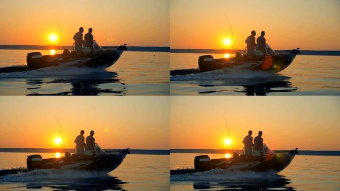 两名渔民正在快艇上穿越日出水景