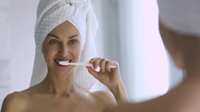 快乐的年轻成年女士照镜子刷牙健康