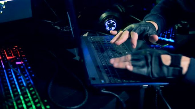 戴着皮手套在键盘上打字的男性手的特写