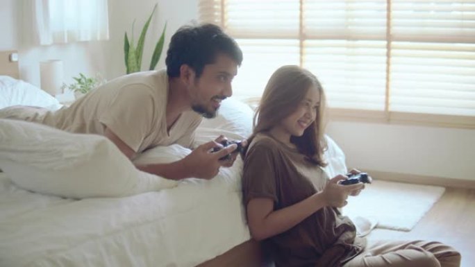 快乐的亚洲夫妇一起在家玩电子游戏