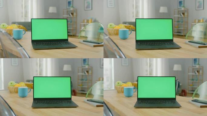 在家里的木桌上拍摄了带有水平绿色屏幕模型的现代笔记本电脑。智能手机躺在电脑旁边的桌子上。