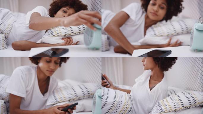 躺在床上睡着的女人伸出手来关掉床头柜上的闹钟，并检查电话上的信息