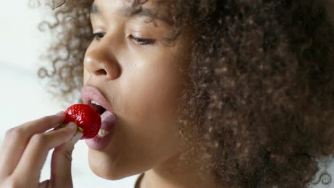 吃草莓的年轻黑人妇女