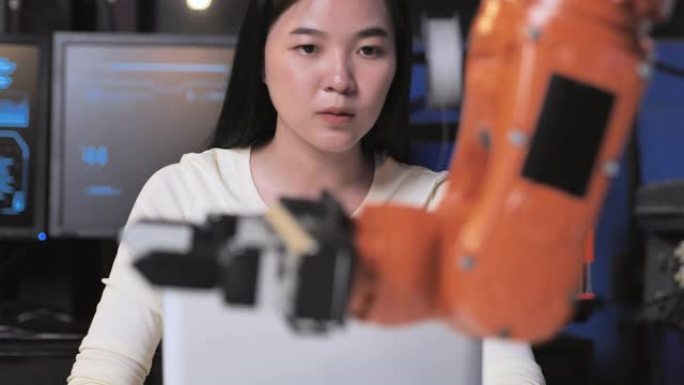 一个未来主义的假肢机器人手臂由一名亚洲少女发展工程师在研究实验室晚工作。手臂移动手指。技术，工作到很