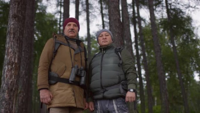 两名高级徒步旅行者在森林里为相机摆姿势
