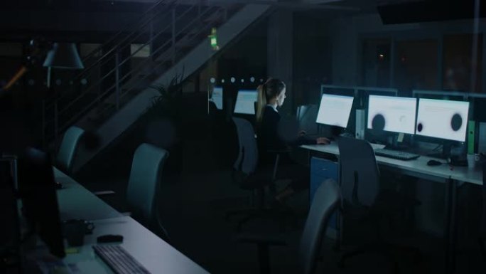 在办公室工作到深夜: 女商人使用台式计算机，分析，使用文档，解决问题，完成项目。