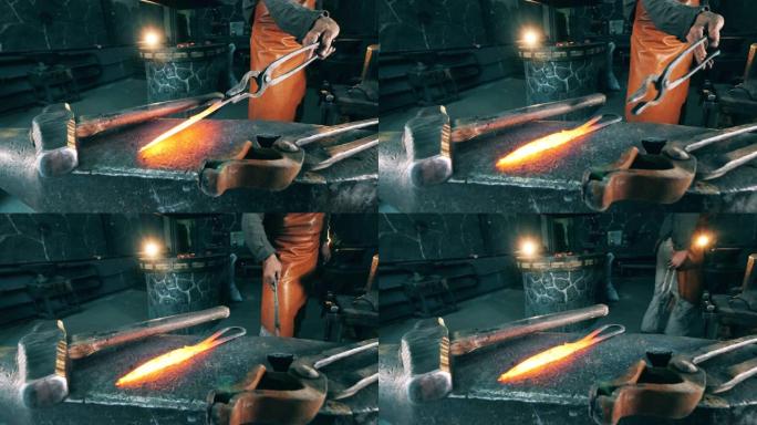 锻造工人把热刀放在铁砧上。