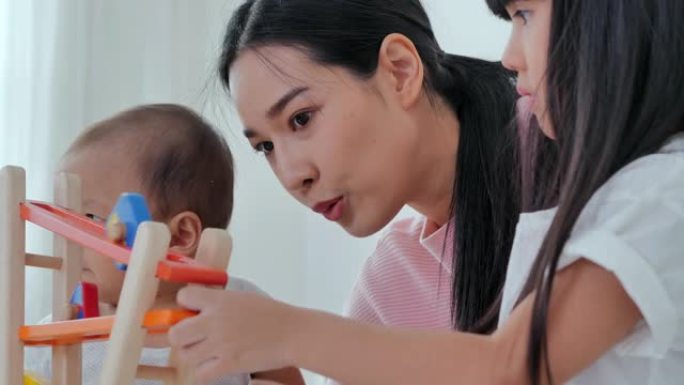 快乐的亚洲家庭单身母亲，孩子们在家里度假时在卧室里玩玩具和微笑。家庭关系，人寿保险，生活方式，情感，