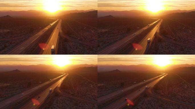 空中: 在日落时分飞越穿越莫哈韦沙漠的卡车和汽车。