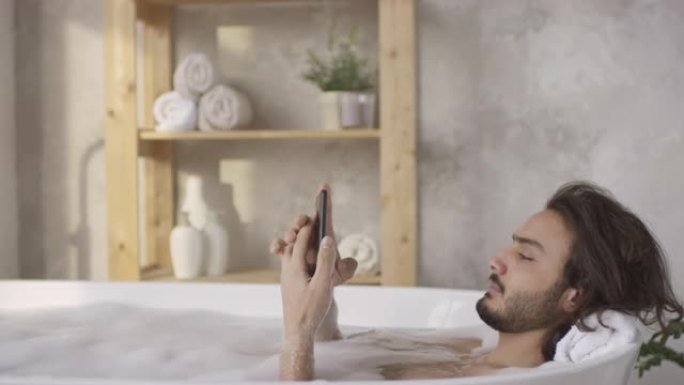 男子躺在浴缸里接电话