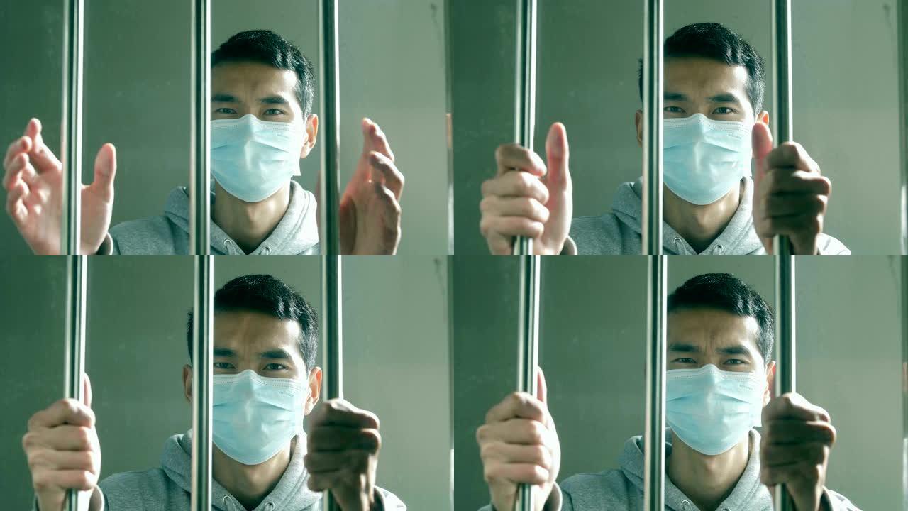 年轻的亚洲男子因病毒感染而被隔离在栏杆后面