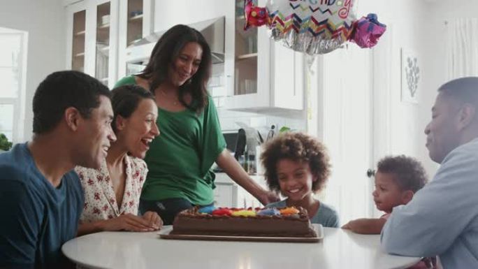 多代家庭坐在厨房的桌子旁庆祝女孩的生日，特写