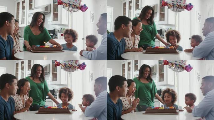 多代家庭坐在厨房的桌子旁庆祝女孩的生日，特写