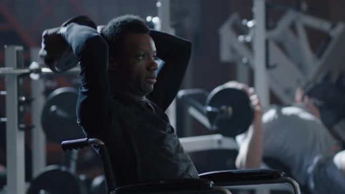 轮椅男子在健身房举重