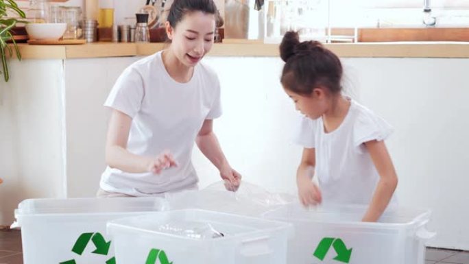 快乐的亚洲母亲教小女孩女儿关于可持续性如何在家中回收生活垃圾，教/学习可重复使用的产品和零废物。家庭