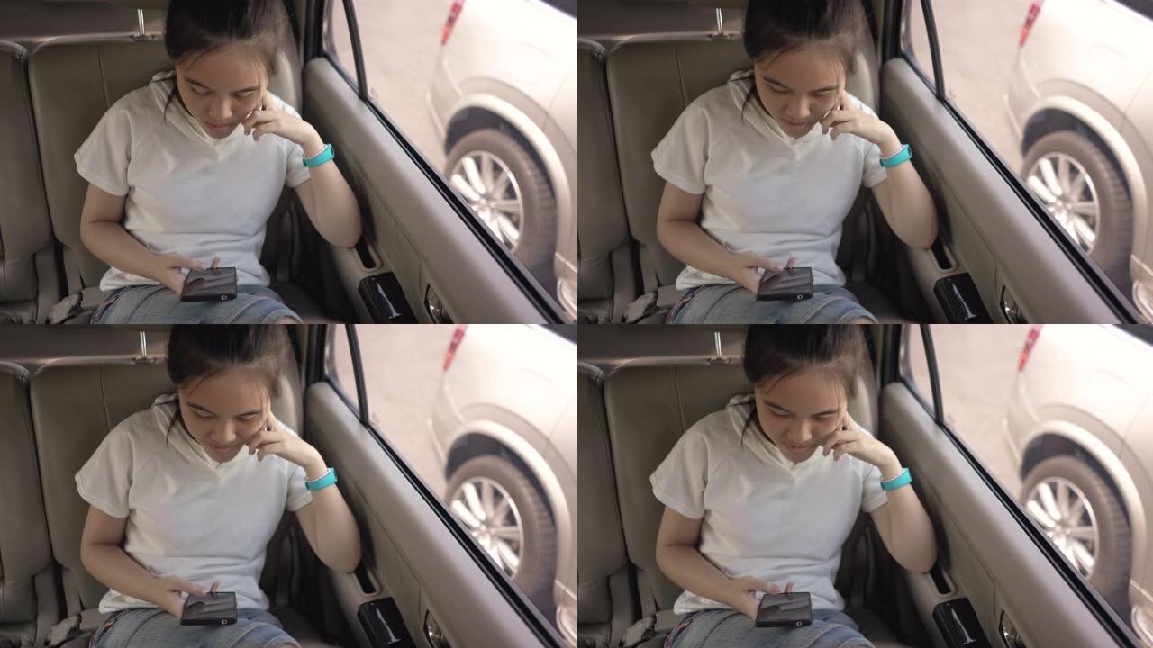十几岁的女孩在购物中心等待母亲购物时在车里使用智能手机