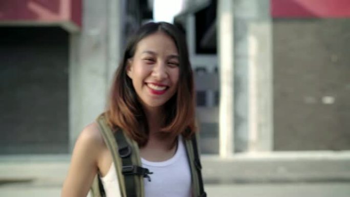 在中国北京唐人街旅行时，开朗美丽的年轻亚洲背包客女人对相机微笑快乐。生活方式背包旅游度假概念。