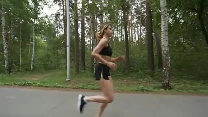 沿着森林路奔跑的运动女人