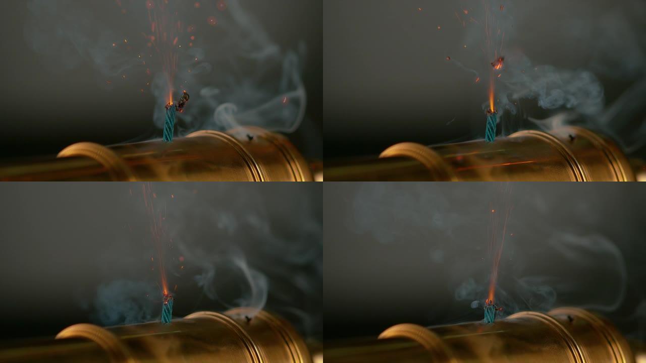 宏观: 发光的火花从黄铜玩具大炮的燃烧保险丝上爆炸。
