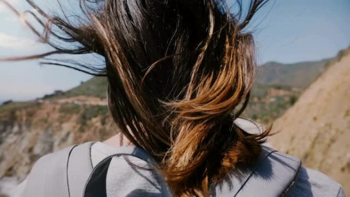 在大苏尔比克斯比峡谷大桥，年轻的旅游女子在强风中飞翔，观看史诗般的风景。