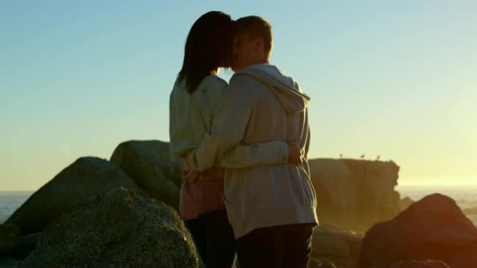 浪漫情侣在岩石海岸4k上互相亲吻