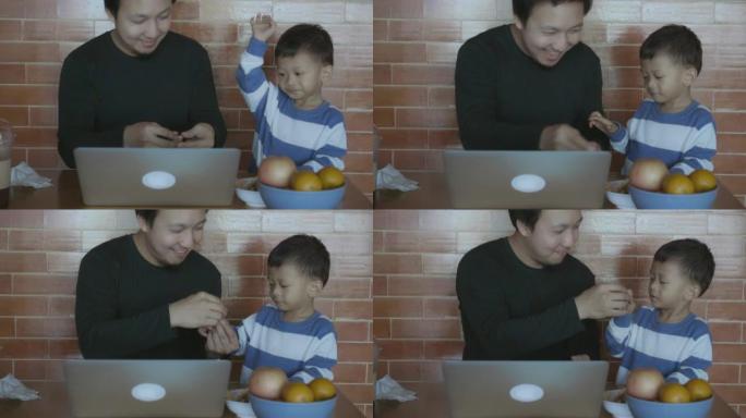 亚洲单身爸爸的4k慢动作镜头在现代阁楼房子里为男孩提供幸福生活，以实现自我学习或家庭学校，家庭和童年