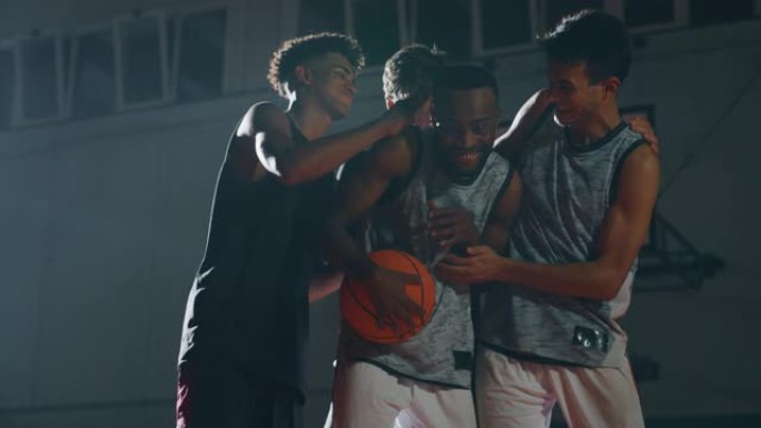年轻职业男球员的电影慢动作镜头在开始在健身房练习篮球锻炼之前一起玩得很开心
